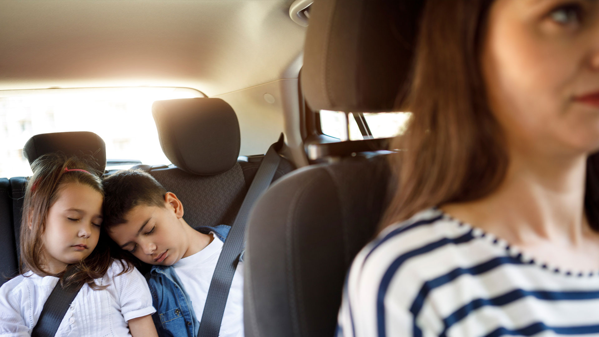 Kids sleeping in the backseat of a car
