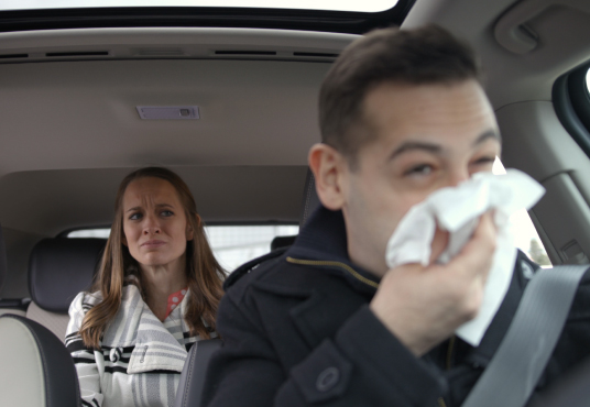 Man eating hamburger in car