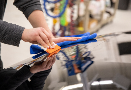 Technician applying coating on car