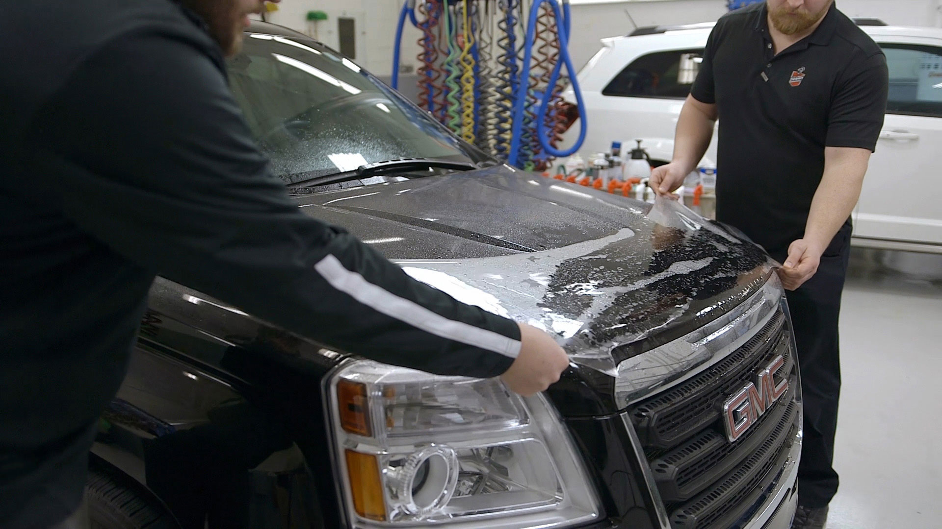 Technician applying coating on car