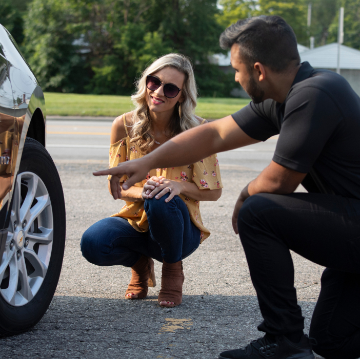 Two People Looking at Car