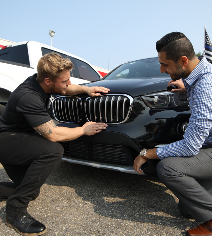 Two People Looking at Car